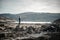 Blonde woman standing on a stone during a fun hike around norwegian fjords on a nice sunny spring day