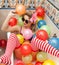 Blonde woman with sunglasses playing in her bath tube with bright colored balloons. Sensual girl with white red striped stockings