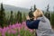 Blonde woman takes photos of Alaska fireweed wildflowers with a smart phone