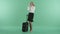 A blonde woman talks on the phone standing near a suitcase