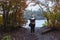 Blonde woman tourist takes photos of Lake Superior along a trail near the beach in autumn