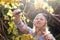 Blonde woman trim branch by small hedge cutter