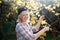 Blonde woman trim branch by small hedge cutter