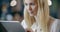 Blonde woman using tablet portrait.Corporate business team work office meeting.Caucasian businessman and businesswoman