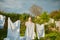 Blonde woman villager hanging wet white-blue laundry on clothesline