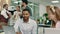 A blonde woman wearing a bandanna at work is talking to her handsome black worker, while in the back by the printer