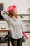 Blonde woman wearing pink gloves feeling tired after cleaning flat