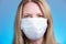 Blonde woman wearing a respiratory face mask. Medical safety, research and corona virus concept