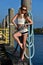 Blonde woman wearing sailor shorts and top posing on the pier.