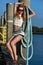 Blonde woman wearing sailor shorts and top posing on the pier.