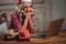 Blonde woman wearing santa hat, working with laptop