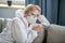 Blonde woman in white workwear and respirator looking tired