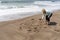 Blonde woman writes Bae slang for Before Anyone Else, representing a romantic relationship in sand on the beach