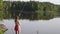 Blonde young girl fisherman is fishing on the forest lake. woman in short dress learns to fish on big river on a