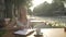 Blonde young girl in white dress in outside cafe terrace table writing thoughts in personal diary journal looking away