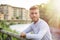 Blondish, blue eyed young man by river smiling