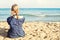 Blone girl on tropical beach vacation, female back against sea, sand and sky