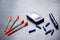 Blood glucose meter, needles and several insulin syringes on a gray wooden table, flat lay