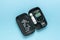 A blood glucose meter with a set of tests in a case on a blue background. The concept of getting rid of diseases