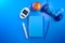 blood glucose meters, notepad and apple on blue desk