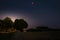 Blood Moon 2018 - The total lunar eclipse and the planet Mars on July 27, 2018. Night landscape with trees and backlight.