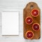Blood oranges halved on rustic wooden board, blank notebook over white wooden surface, top view. Flat lay, overhead, from above