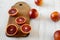 Blood oranges halved on rustic wooden board over white wooden surface, side view. Closeup