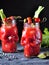 Bloody Mary cocktail in glasses-skull with celery sticks, pink salt, lime and canapes from canned vegetables.