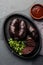 Bloody sausages - chilean preta on iron plate, top view, grey slate background