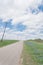 Blooming bluebonnet along country road with white picket fence and row of power pylons in Ennis, Texas, USA