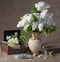 Blooming branches of lilac in vase and dollars in chest