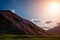 Blooming carpet of pink rhododendron flowers covers the mountain slopes at sunset. Incredible natural landscape. Vintage photo