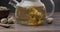 Blooming flower tea ball brewing in a glass teapot with Hot boiling water on wooden background