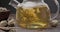 Blooming flower tea ball brewing in a glass teapot with Hot boiling water on wooden background