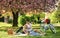 Blooming garden. Perfect spring date. Romantic picnic. Man and woman in love. Couple sit blanket. Happy together. Picnic