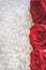 Blooming red roses in white floral lace background. Valentine`s Day or romantic celebration concept, with copy space.