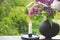 Blooming spring lilac flowers and burning candle in a candlestick. Spring background