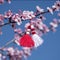 Blossoming tree branch and martenitsa against blue sky. Martisor and spring bloom. Baba Marta Day - Bulgarian holiday