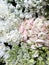 Blossoming white, pink, and green flowerbed of ranunculus, hydrangea, lilac. Top view, close up