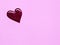 Blot of purple nail polish shaped heart isolated on pink