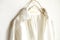 A blouse or shirt in white hanging on clothes hanger on white background.Close up