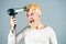 Blow-dry your hair. Bearded fun young man hold blow dry hair isolated on gray background, studio portrait. Haircare