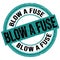 BLOW A FUSE text written on blue-black round stamp sign