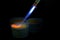 Blow torch caramelizing ramekin of creme brulee. Isolated on black.