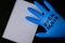 Blown up blue latex surgical glove on black background. Reopening covid safe. Open again text written on medical glove