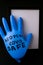 Blown up blue latex surgical glove on black background. Reopening covid safe. Open again text written on medical glove. New normal