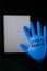 Blown up blue latex surgical glove on black background. Reopening covid safe. Open again text written on medical glove. New normal