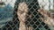 Blows on mesh fence with womens hands. Angry girl beats hands on a grid fence