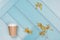 On a blue, abstract background, dry yellow flowers and a paper cup from under the coffee. Nice layout, there is a place for text.