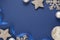 Blue abstract Christmas minimalistic styled background with silver snowflakes, baubles and blue ribbon. Blue mock up with space